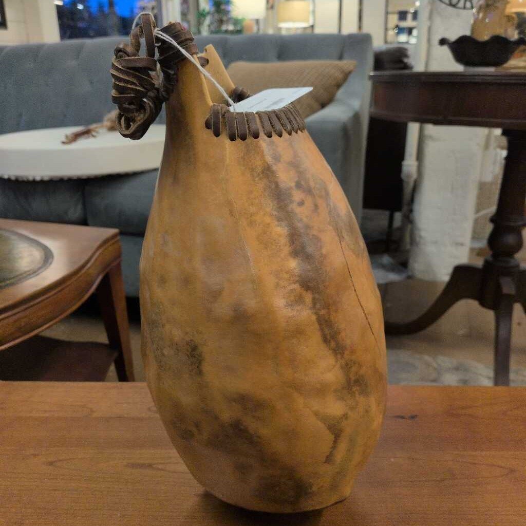 Vintage-style gourd vase on a wooden table with a blurred indoor background