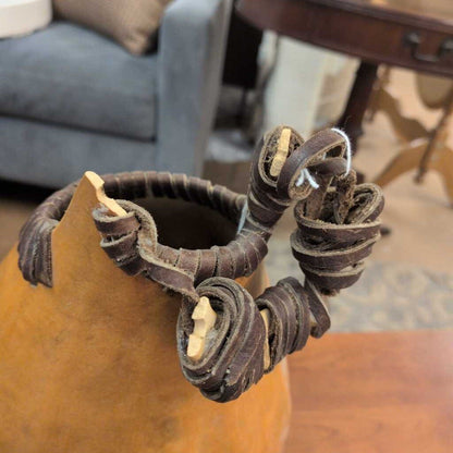 Decorative wreath made of leather straps on a wooden surface with a blurred background