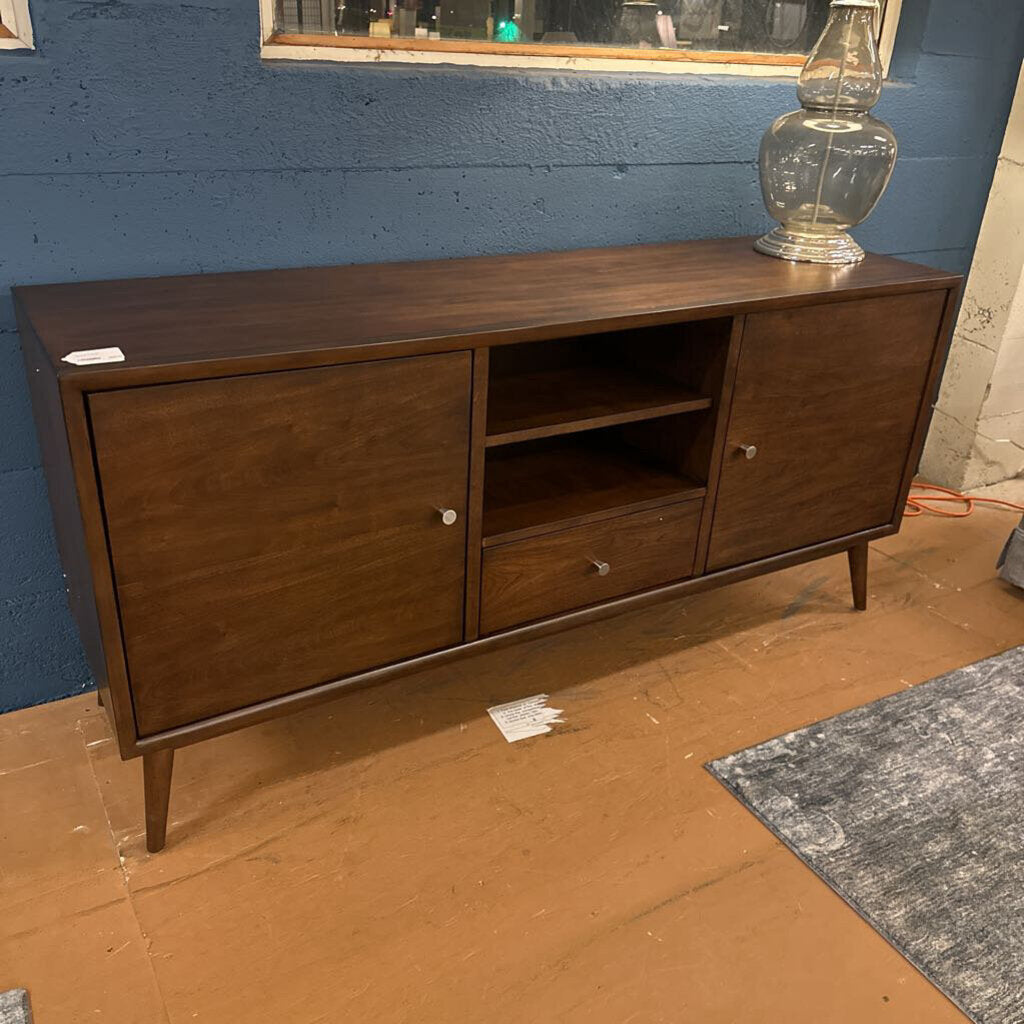 Wooden sideboard against a blue wall with a lamp on top