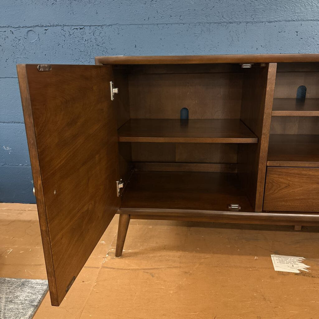 Wooden cabinet with open door against a blue wall