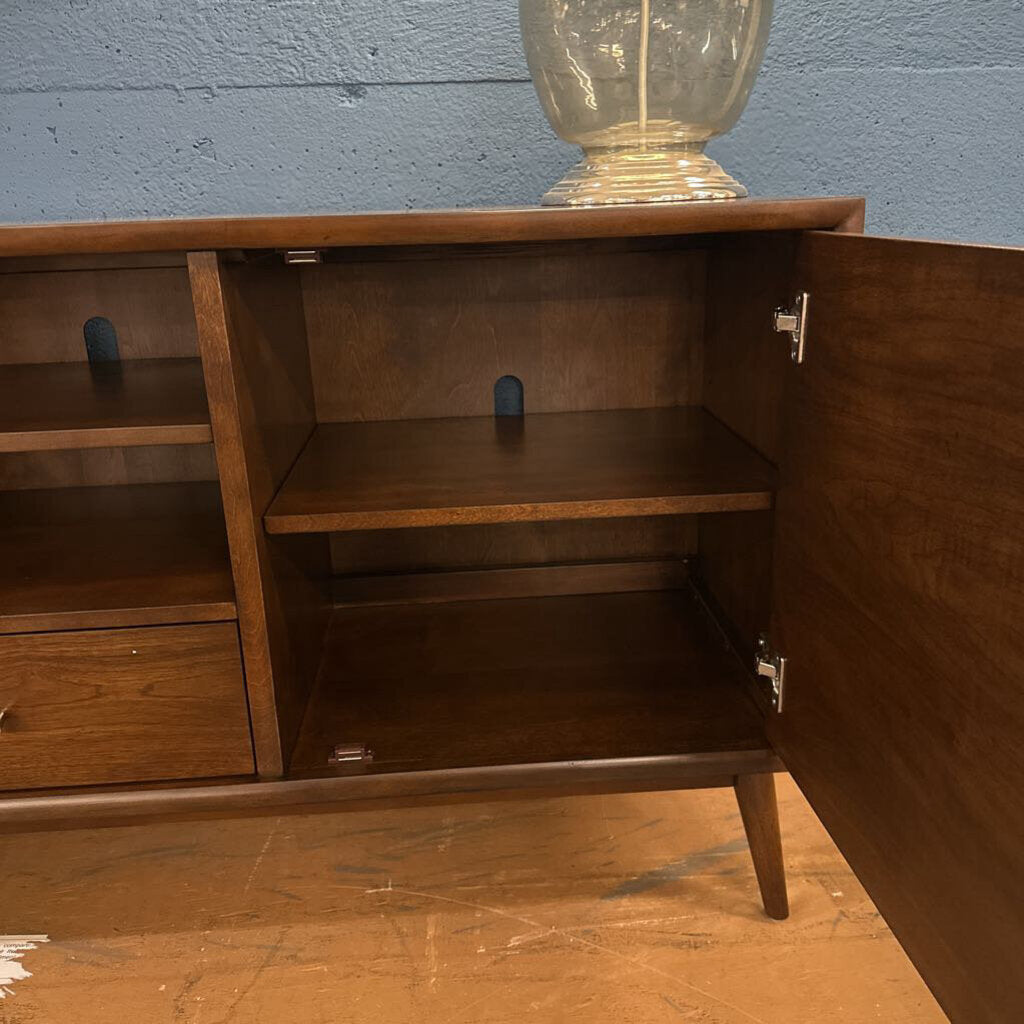Wooden cabinet with open door against a blue wall