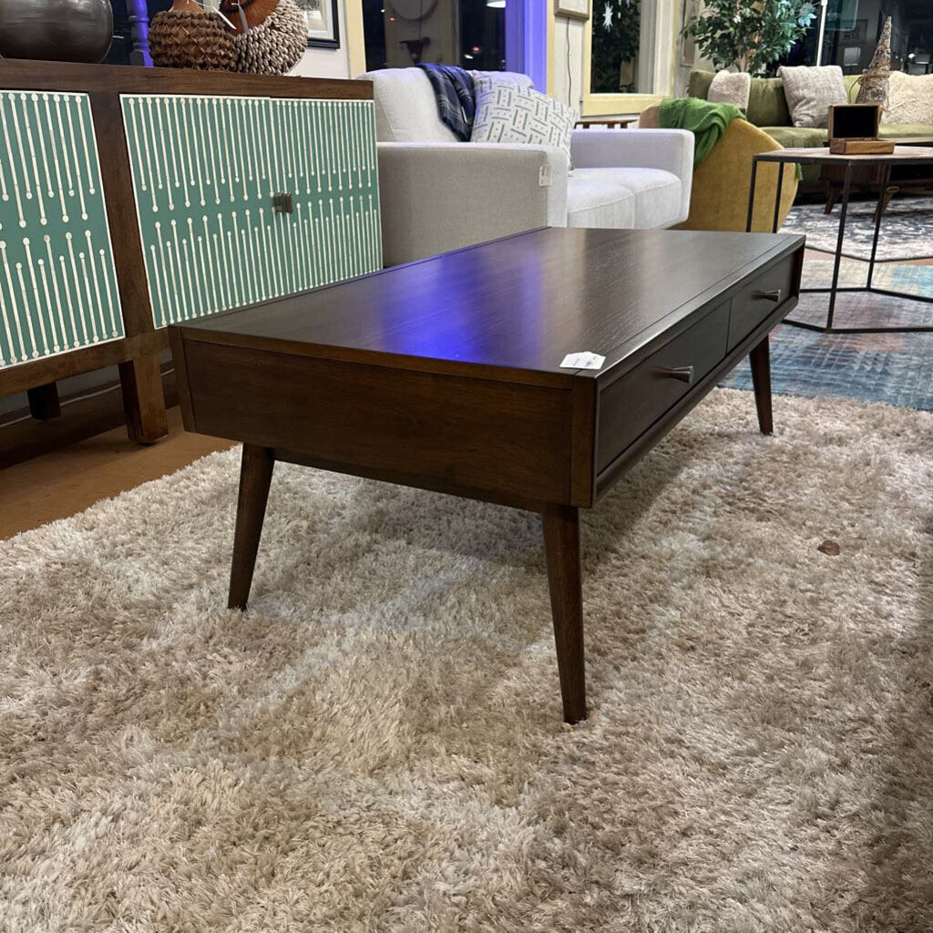 Wooden coffee table in a living room setting with furniture and decor.