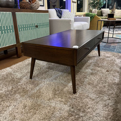 Wooden coffee table in a living room setting with furniture and decor.