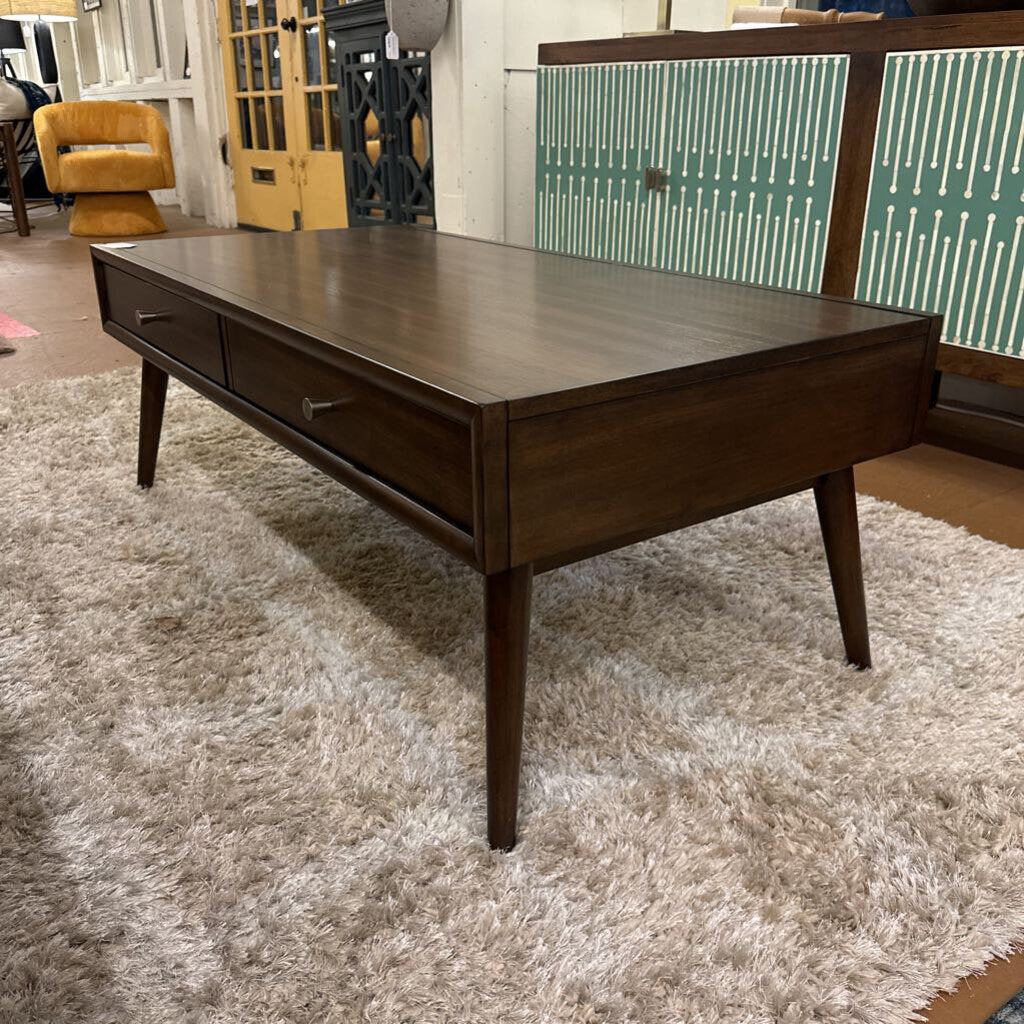 Wooden coffee table on a textured rug with a blurred background