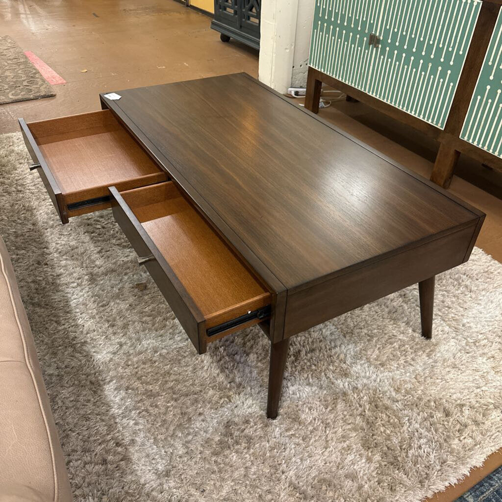 Wooden desk with two drawers on a carpeted floor