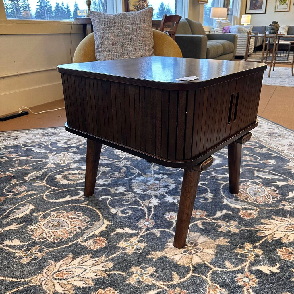 Wooden coffee table in a living room setting with a patterned rug