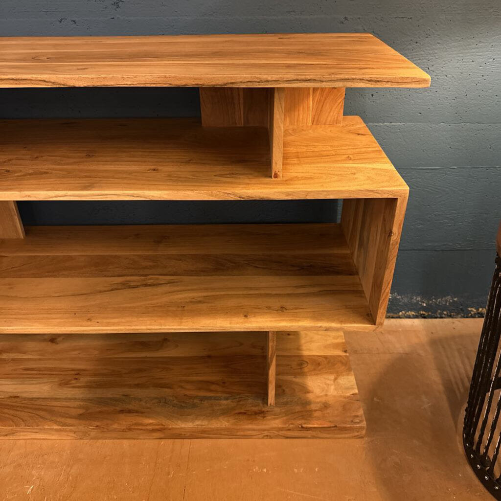 Wooden TV stand against a gray wall