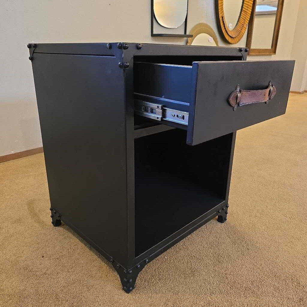 Black metal cabinet with open drawer on a carpeted floor