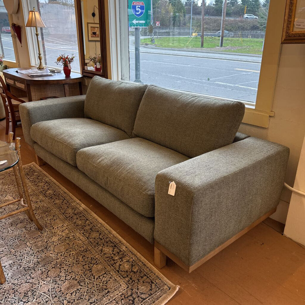 Gray sofa in a room with a window view of a street.