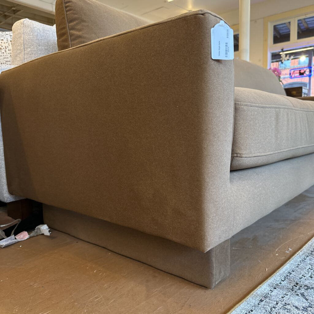 Beige sofa with a price tag in a store setting