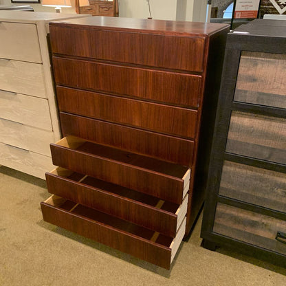 Wooden dresser with multiple drawers in a showroom setting
