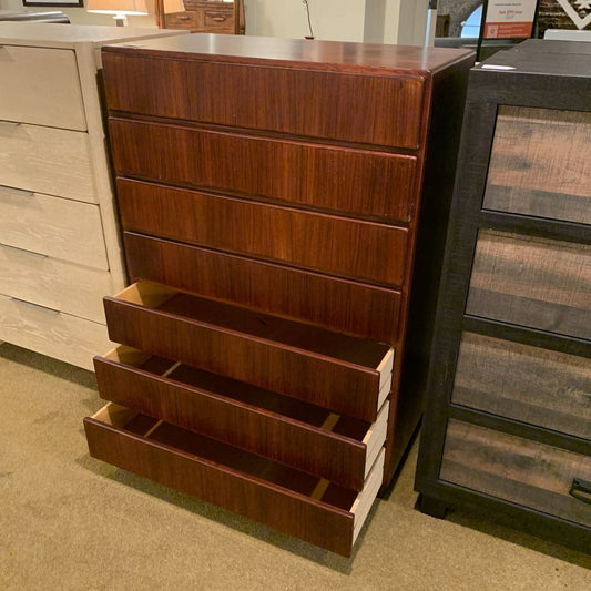 Wooden dresser with multiple drawers in a showroom setting