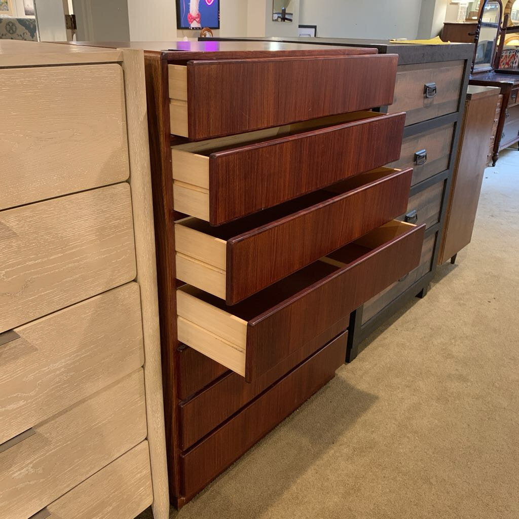 Wooden dresser with multiple drawers in a store setting