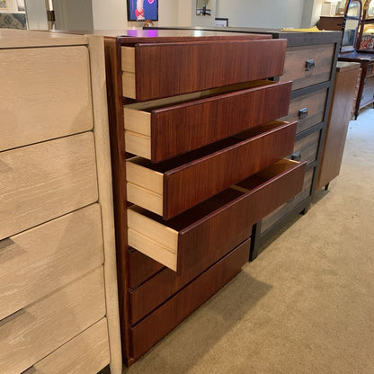 Wooden dresser with multiple drawers in a store setting