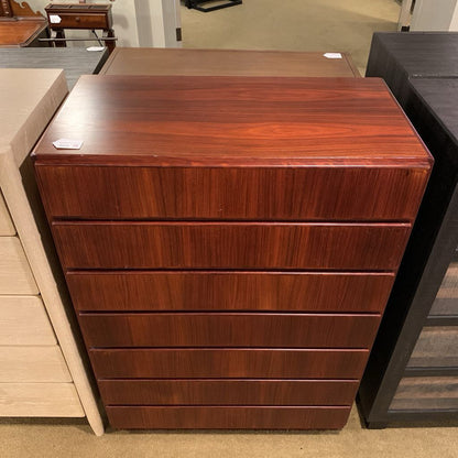 Wooden dresser with multiple drawers in a store setting