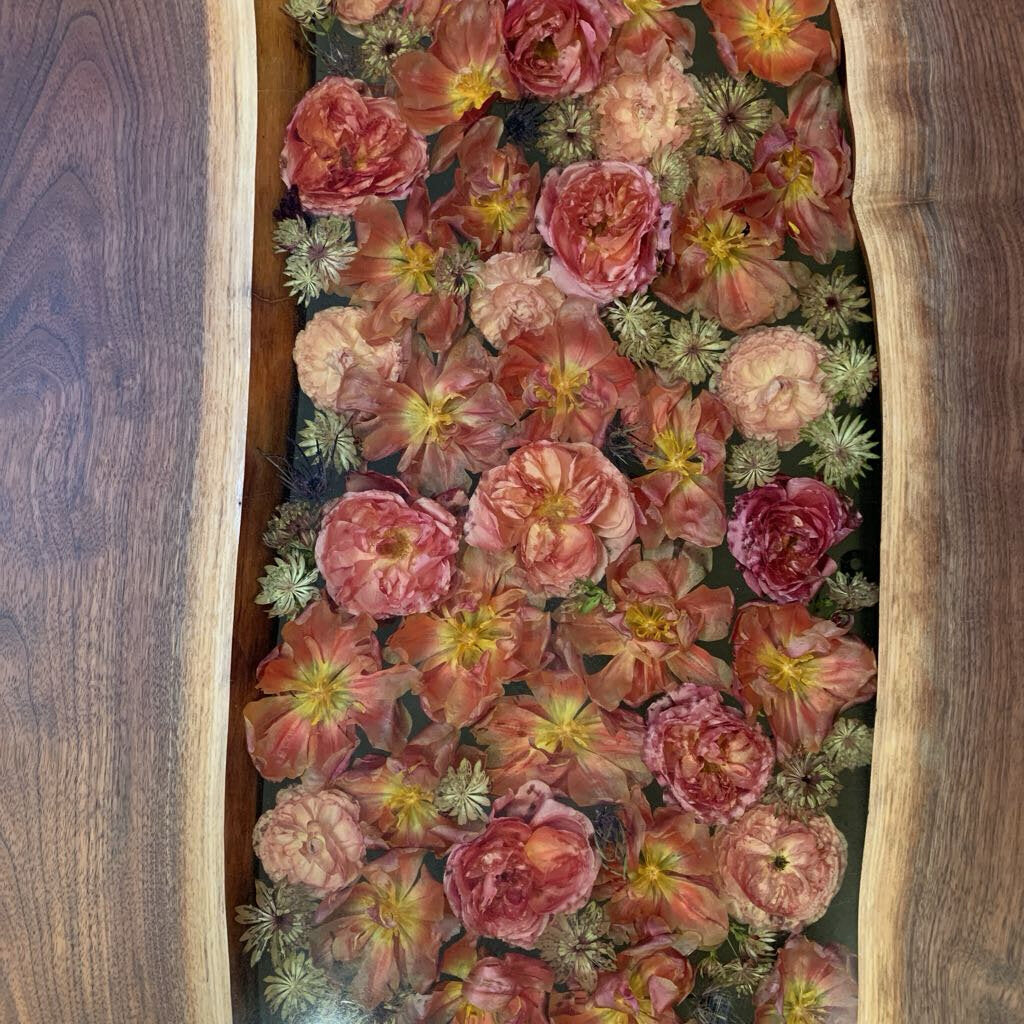 Floral arrangement in a wooden frame on a wooden surface