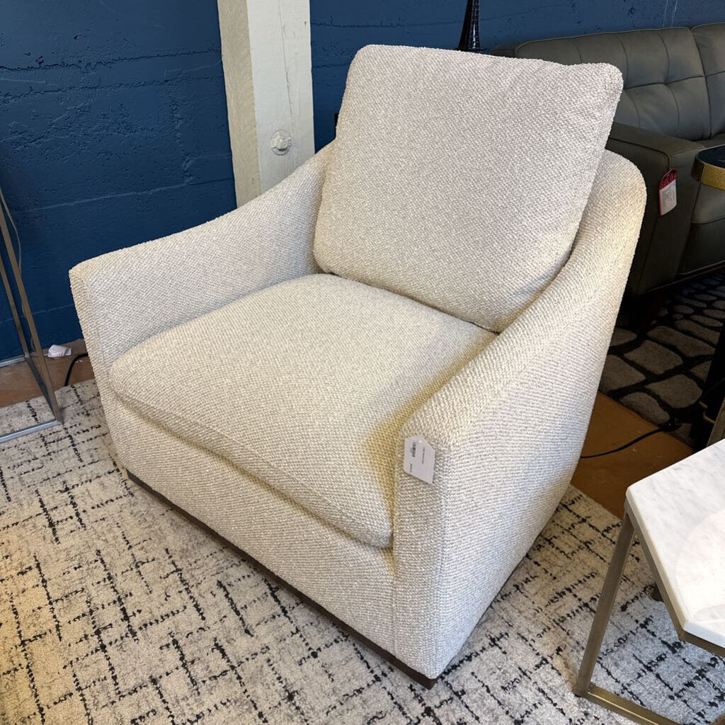 Beige armchair in a room with a blue wall and patterned rug
