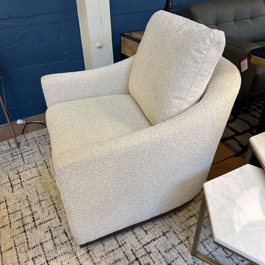 Beige armchair in a room with a blue wall and other furniture.