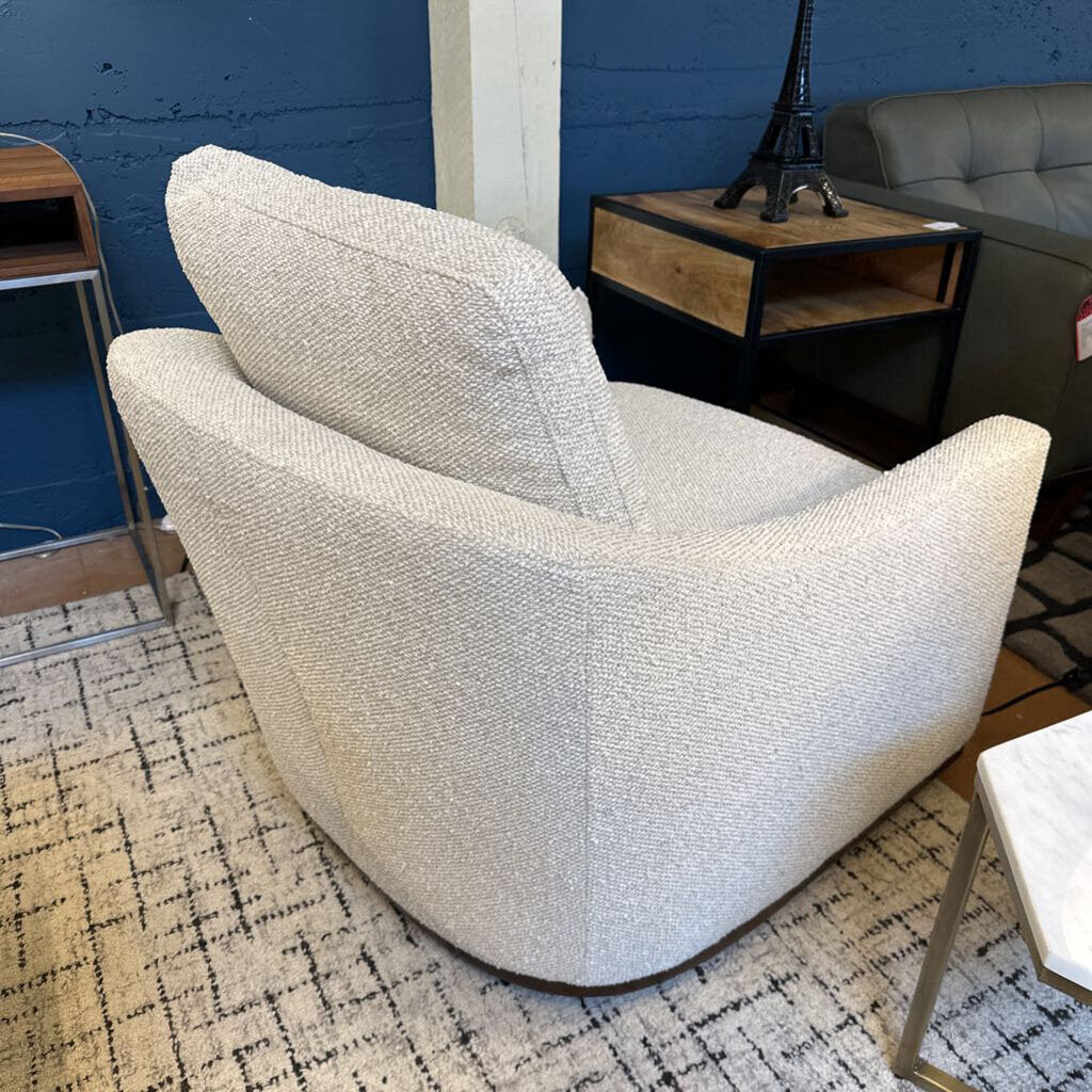 White textured armchair in a room with a blue wall and a small table.