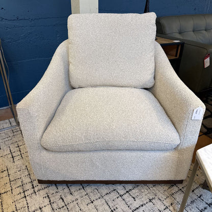 Beige armchair with a textured pattern in a room setting.