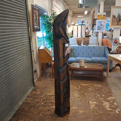 Tribal sculpture in a store with furniture and decor in the background