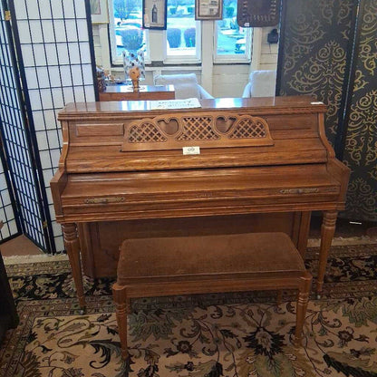 Wooden piano with a matching bench on a patterned rug