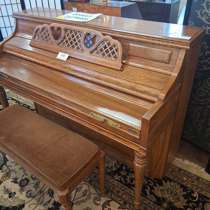 Wooden upright piano with a bench on a patterned rug