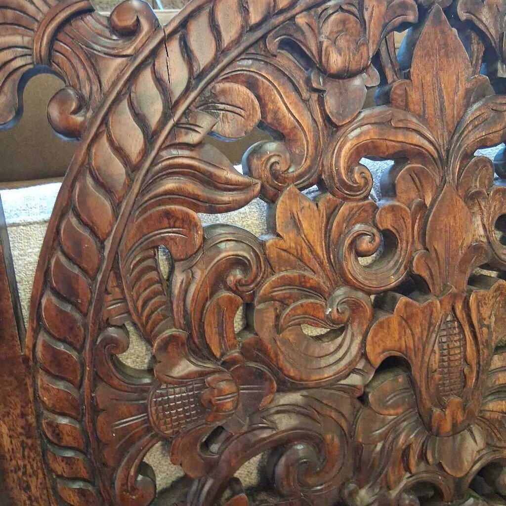 Close-up of intricately carved wooden panel with floral patterns