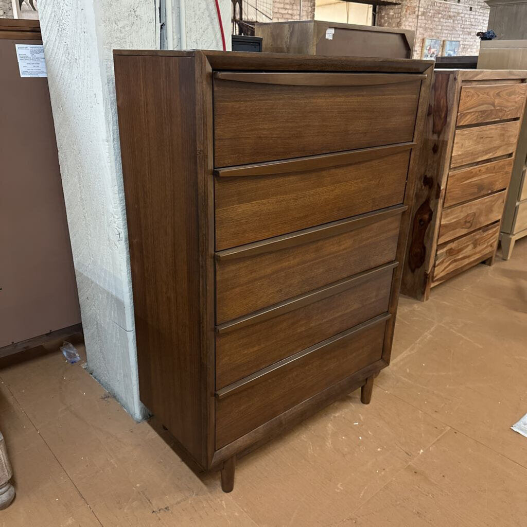 Wooden dresser with multiple drawers in a storage or warehouse setting