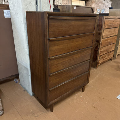 Wooden dresser with multiple drawers in a storage or warehouse setting