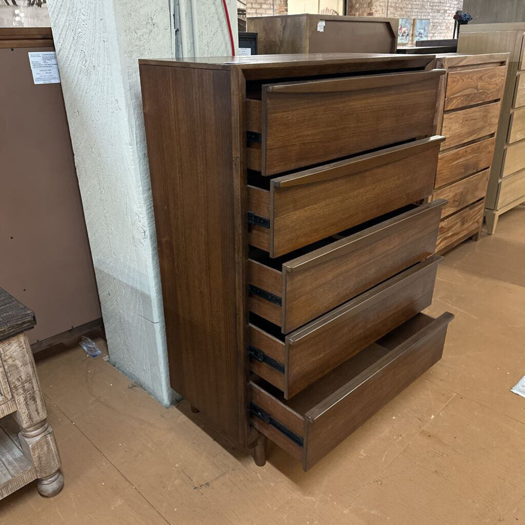 Wooden dresser with multiple drawers in a storage or warehouse setting.