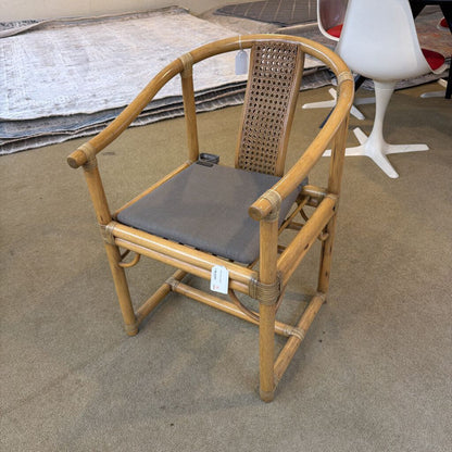 Bamboo chair with a gray cushion on a concrete floor