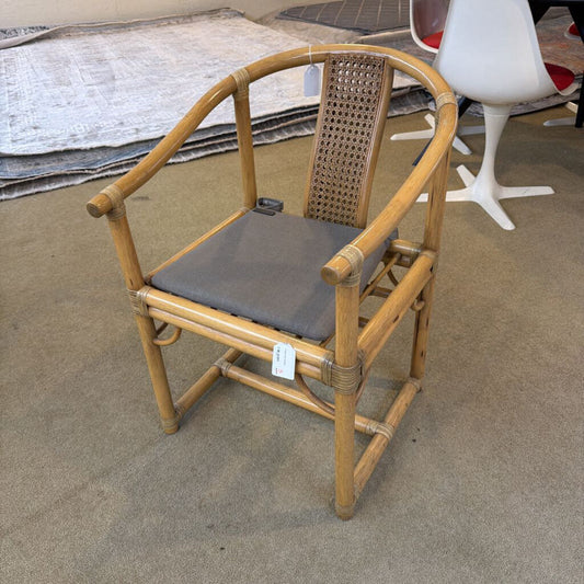 Bamboo chair with a gray cushion on a concrete floor