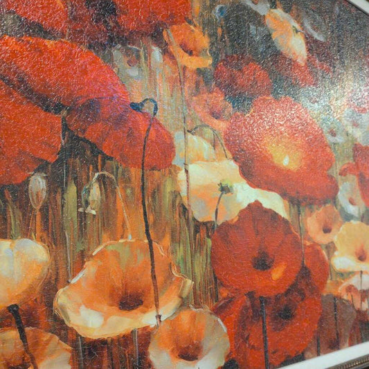 Close-up of a painting of red and orange flowers with a textured surface.