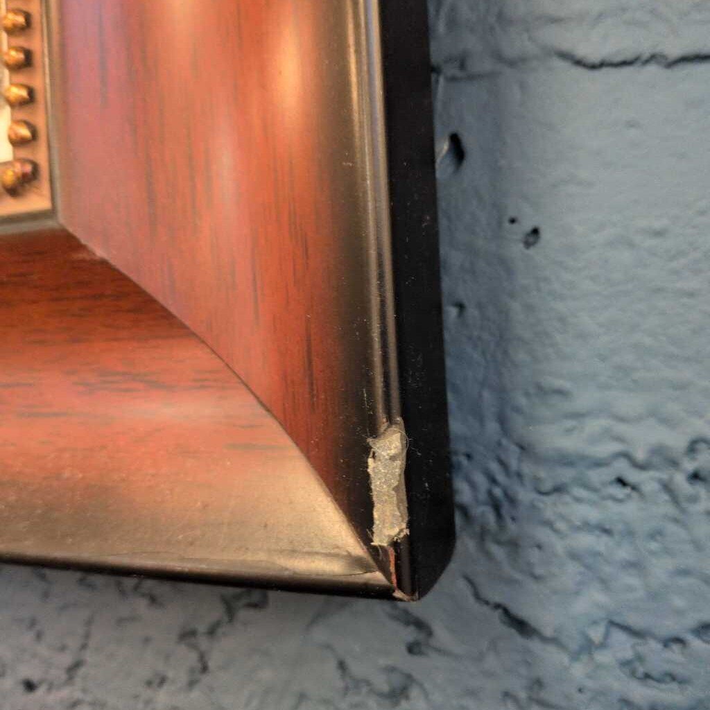 Close-up of a wooden frame corner with a textured blue wall background