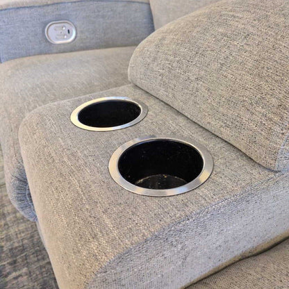 Gray fabric chair with cup holders on a wooden floor