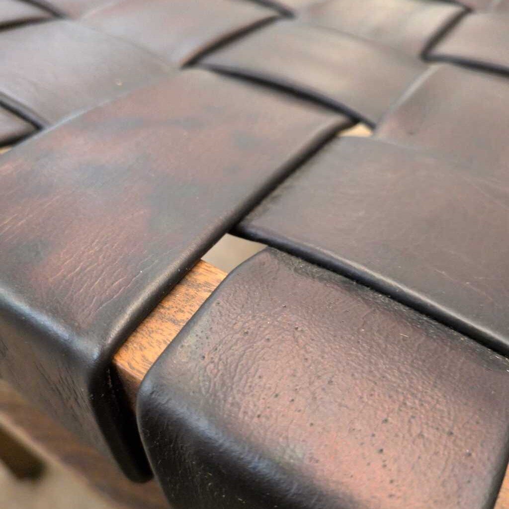 Close-up of woven leather with a wooden strip