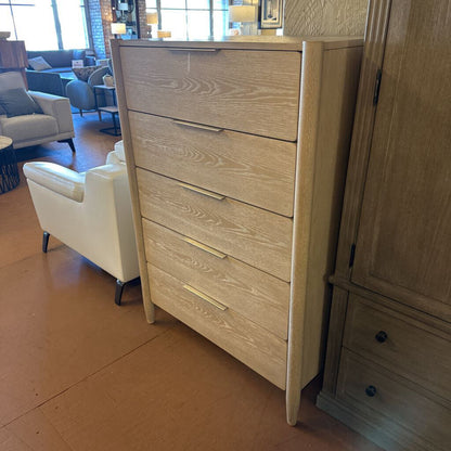 Wooden dresser with multiple drawers in a room with furniture and decor.
