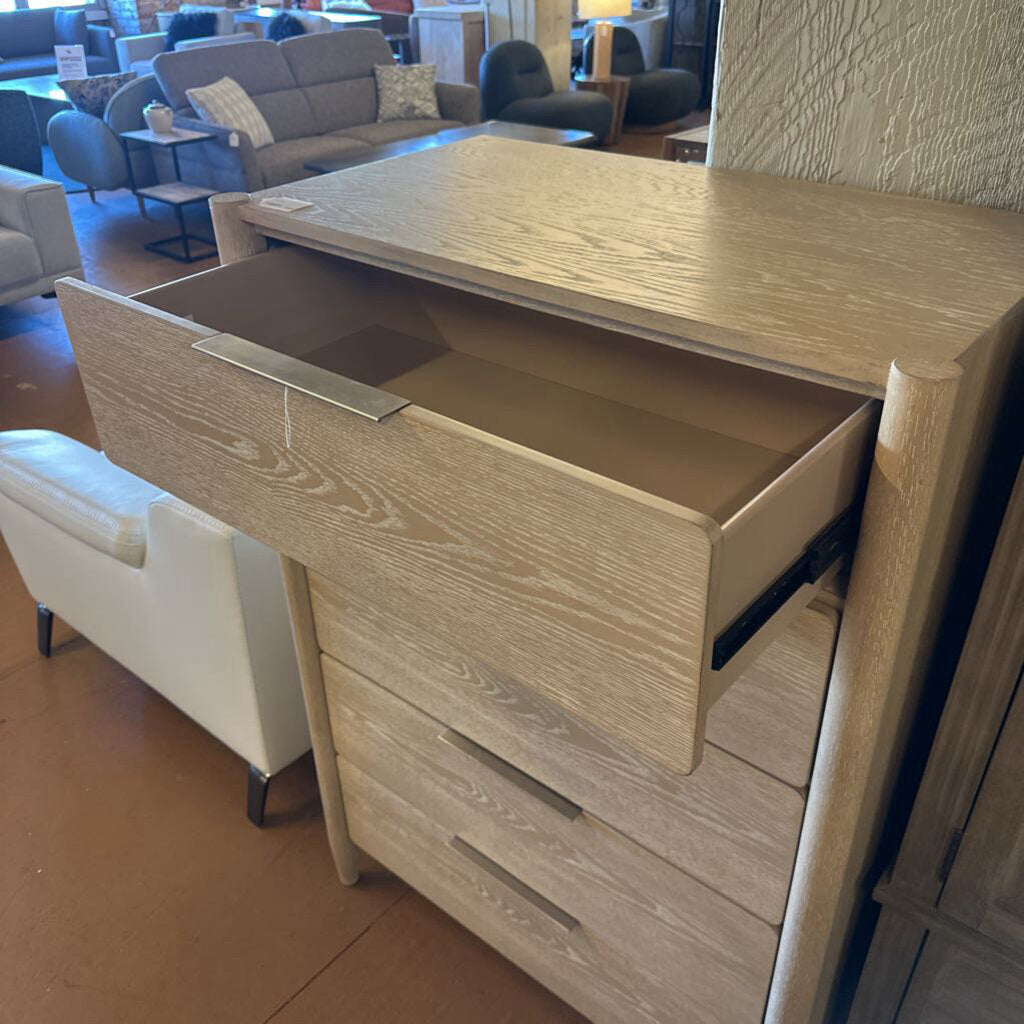Wooden dresser with open drawer in a furniture store setting