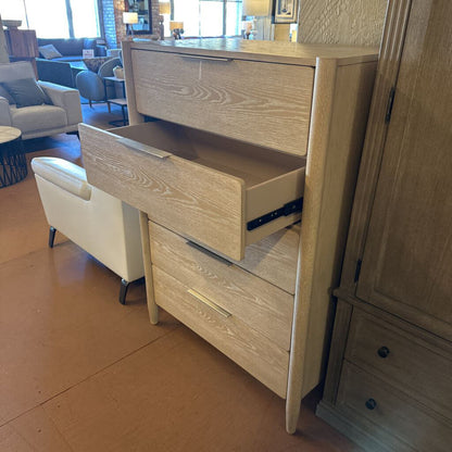 Wooden dresser with open drawer in a room with furniture and decor.
