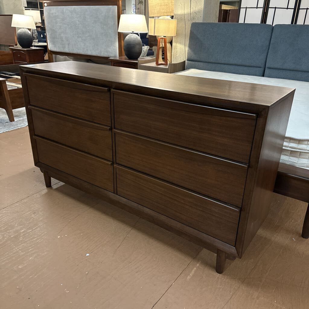 Wooden dresser in a room with a sofa and lamps