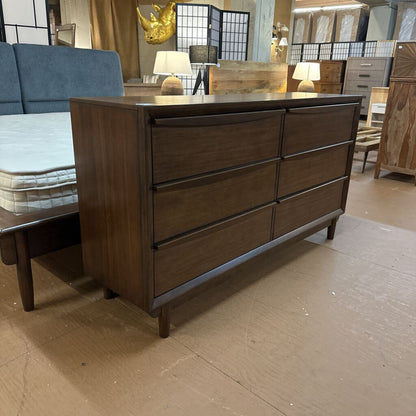 Wooden dresser with multiple drawers in a showroom setting