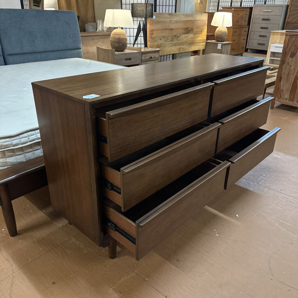 Wooden dresser with multiple drawers in a bedroom setting