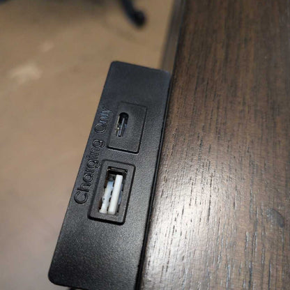 Black electronic device with charging ports on a wooden surface