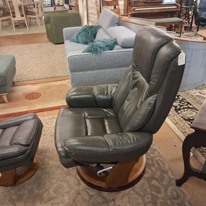 Leather recliner chair in a showroom setting with other furniture.