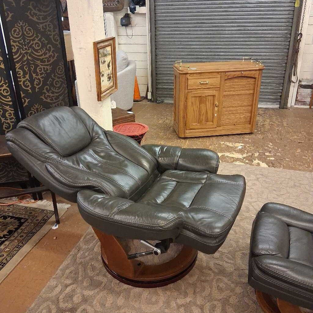 Leather recliner chair in a room with a wooden cabinet and various decor items.