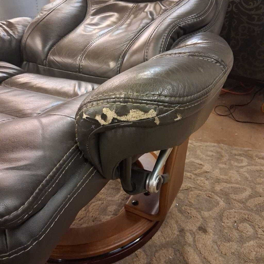 Brown leather recliner chair with visible wear on a carpeted floor