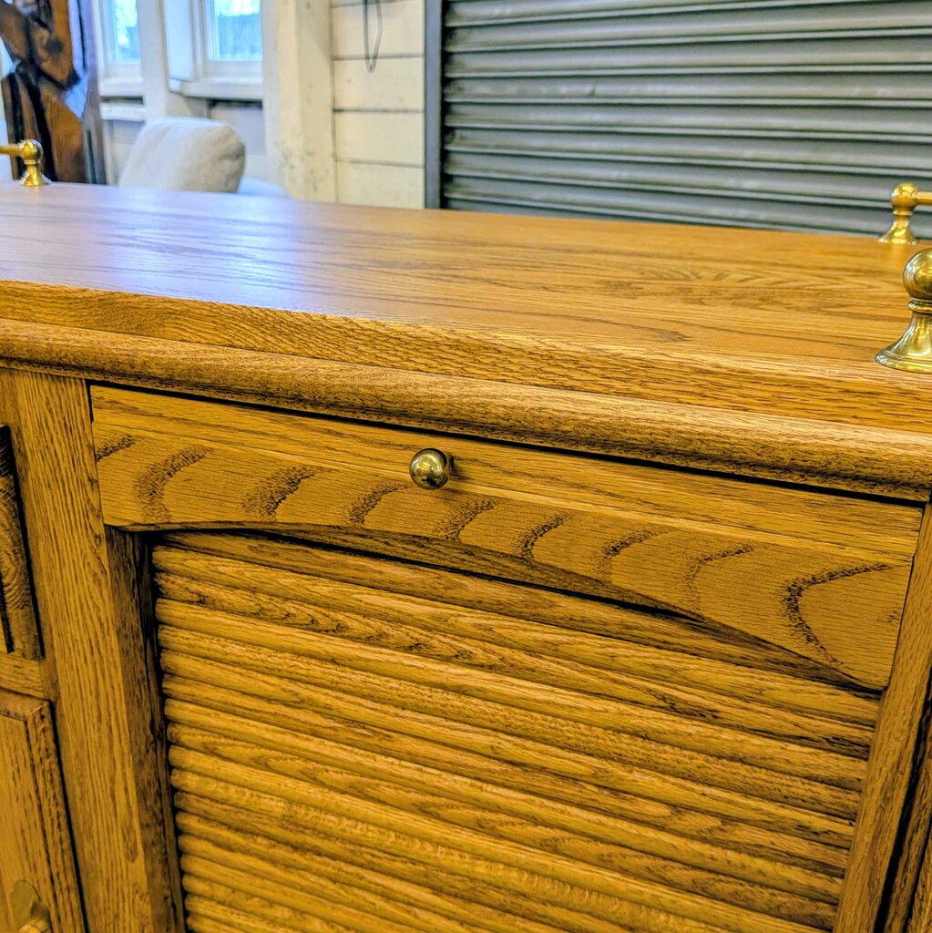 Wooden dresser with gold handles in a room setting