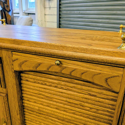 Wooden dresser with gold handles in a room setting
