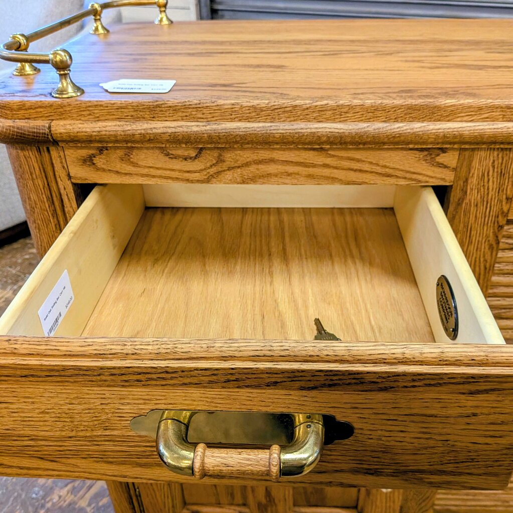 Wooden drawer with gold handle and interior, showing a close-up of the interior surface.